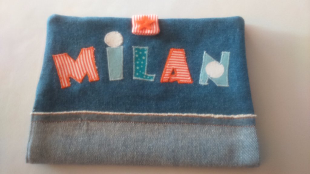 Protège carnet  'Fusée dans la lune' personnalisé pour Milan
Taille standard  - En Jean et coton imprimé, doublé de viseline pour la solidité . L'attache est une bande à scratch